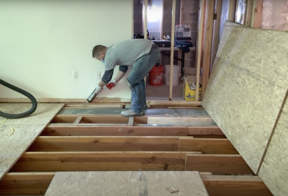 man using caulking gun for flooring