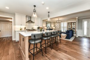 A beautiful modern kitchen with wood flooring and white countertops